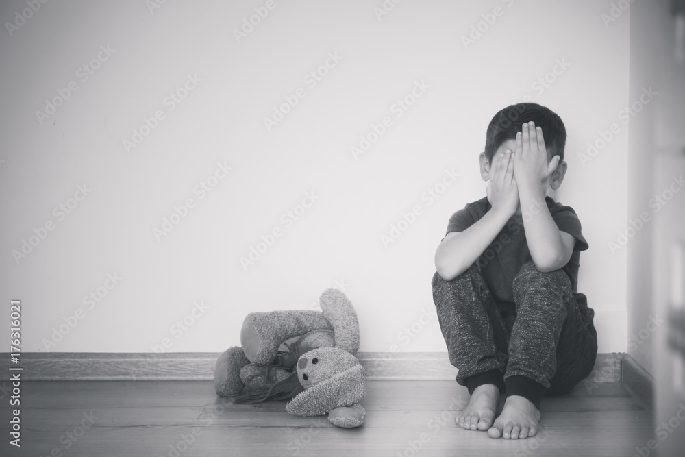 Little sad boy sitting on floor at home - obrazy, fototapety, plakaty 