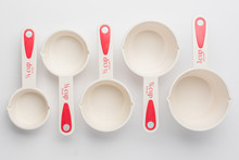 Set of Measuring Cups Staggered on White Background Top View