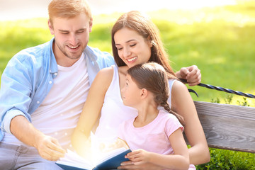 Wall Mural - Happy family reading book in park