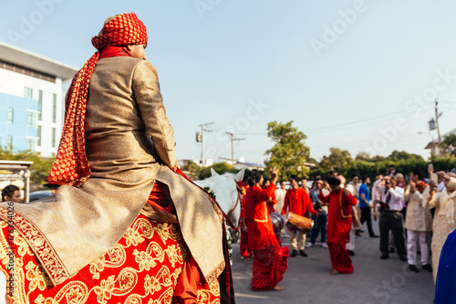 Indian Groom Ridding White Horse With Yellow And Red Pattern