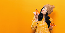 Young Woman Holding A Pumpkin In Halloween Theme