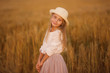 © viclin - Portrait of a cute beautiful girl with long hair on the background of a wheat field on a summer evening