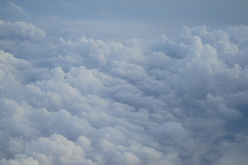 Wall Mural - shades of light blue color sky and floating white cloud wonderland view from airplane window
