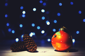 Wall Mural - Christmas pinecone on shiny background. Pine cone on the background of blue Christmas lights blurry