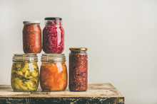 Autumn Seasonal Pickled Or Fermented Colorful Vegetables In Glass Jars Placed In Stack Over Vintage Kitchen Drawer, White Wall Background, Copy Space. Fall Home Food Preserving Or Canning