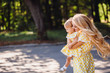 Cheerful blonde mother walks with little girl in the park