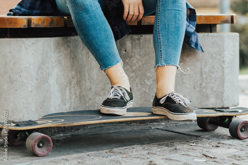 Plakat Kobiece nogi na longboardzie przy ulicy