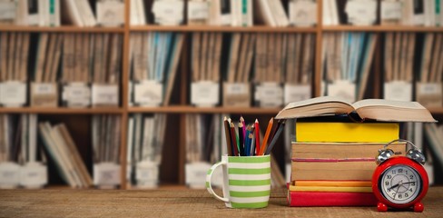 Canvas Print - Composite image of stack of books by mug with colored pencils