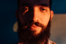 Portrait Of Bearded Man Against The Blue Wall On Sunset Light
