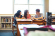 © Rob and Julia Campbell/Stocksy - Three high school students studying together in library