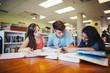 © Rob and Julia Campbell/Stocksy - Three high school students studying together in library