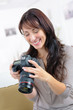 © auremar - smiling female photographer checking picture preview on camera screen