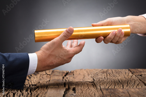 Cuadros en Lienzo Close-up Of A Businessperson Passing Baton
