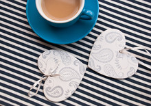 Cup Of Tea With Two Wooden Hearts On Striped Fabric. Top View Of Romantic Breackfast.Winter Time Valentine Day.