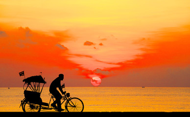 Sticker - silhouette old man ride Tricycle on colorful sky background