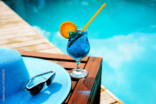 Zdjęcie XXL Kapelusz letni, koktajl i okulary przeciwsłoneczne w pobliżu luksusowego basenu.
