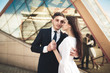 © olegparylyak - Elegant beautiful couple posing near modern glass building
