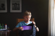 © Connect Images - Boy packing backpack with school stationery supplies