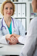 © rogerphoto - Doctor and patient shaking hands, close-up.  Physician talking about medical examination results. Medicine, healthcare and trust concept