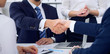 © rogerphoto - Business handshake at meeting or negotiation in the office, close-up. Partners are satisfied because signing contract or financial papers