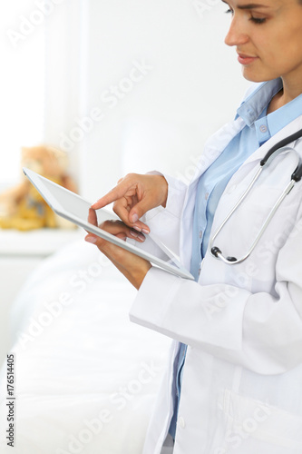 Zdjęcie XXL Kobiety doktorski używa pastylka komputer podczas gdy stojący prosto w szpitalu