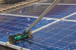 Cleaning solar panels on house roof - Solar Energy Concept Image