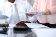 © rogerphoto - African american bookkeeper or financial inspector  making report, calculating or checking balance. Internal Revenue Service checking financial document. Audit concept