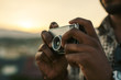 © BONNINSTUDIO/Stocksy - Young black man taking a photo with an old camera at sunset.