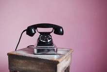 Old-fashioned Black Telephone On Pink Background