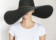 © Wave/Stocksy - Young woman wearing a big black hat