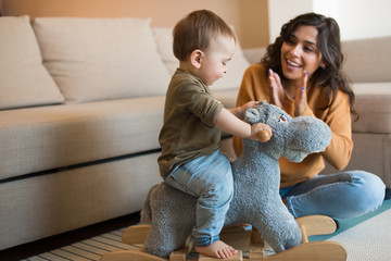 Wall Mural - Baby playing with a rocking horse