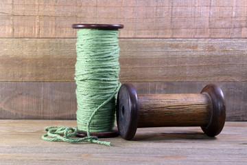 Wall Mural - This is a photo of two wooden vintage bobbins with yarn.