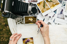 Woman Looking At  Photos With Flowers Attached To Them