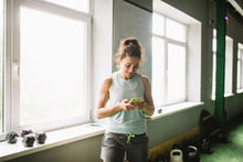Girl In The Gym Near The Window Uses A Smartphone