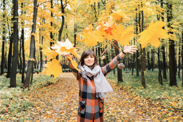 Autumn girl walking in city park. Portrait of happy lovely and beautiful young woman in forest in fall colors.