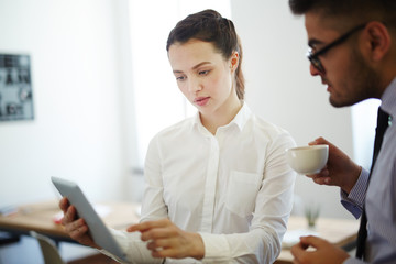 Sticker - Confident businesswoman pointing at tablet display and explaining financial data to colleague