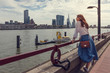 © papa - A young woman walks along the promenade of Rotterdam, enjoying the view.