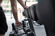 © 88studio - young man execute exercise in fitness center. male athlete choose dumbbell in gym. sporty guy working out in health club.