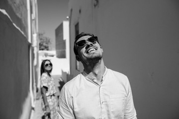 Wall Mural - Happy couple hugging and laughing together with a view of Santorini, black&white photo