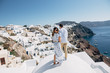 The couple is standing on the roof in Santorini