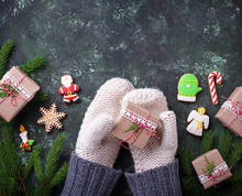 Hands In Mittens Holding Christmas Gift Box