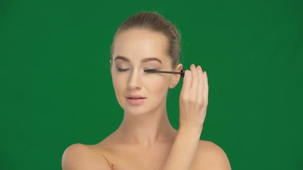 Wall Mural - Girl applies mascara on the eyelashes with a makeup brush