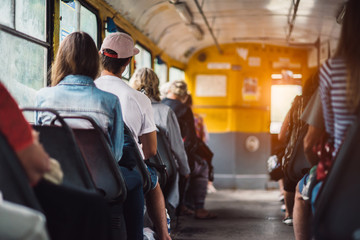 People have a ride in public transport from the work at sunset time