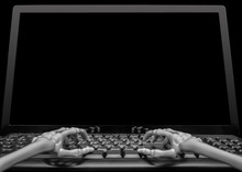 View Of Two Skeleton Hands Typing On A Keyboard In Front Of A Blank Computer Screen Ready For Someone To Fill With Graphics Or Text.