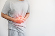 a man pressing his stomach, with red highlight of stomach pain and others stomach disease concept, on white background with copy space