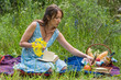 © allenkayaa - Picnic in nature at summer. Young woman in romantic blue dress is reading a book