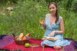 © allenkayaa - Young woman in romantic blue dress at a picnic. Girl is reading a book and drinking white wine at nature