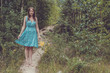 © allenkayaa - Young woman in romantic blue dress with yellow flowers in the mountains