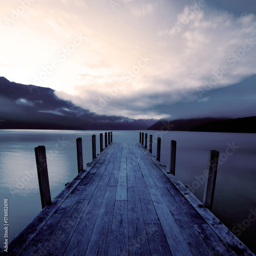 Fotografía Boat jetty and a calm lake at sunrise, New Zealand.