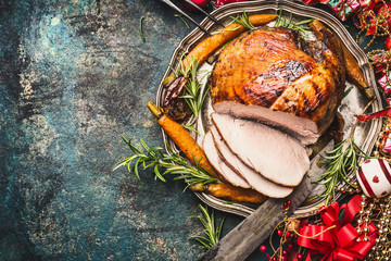 Christmas ham served with roasted vegetables and festive decorations on vintage background, top view, place for text. Christmas recipes and dishes concept